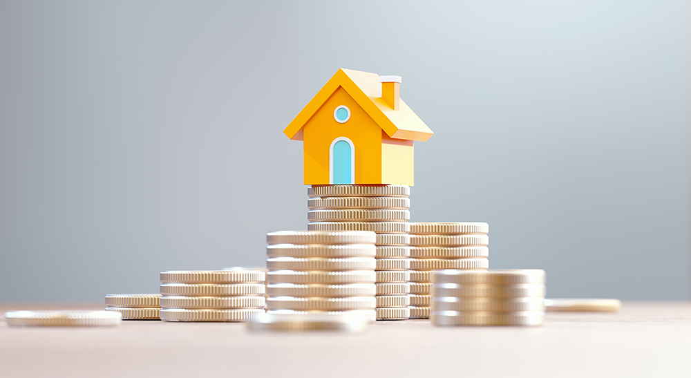 Haus auf Münzstapeln – Symbol für Immobilienkapital und Liquidität im Alter